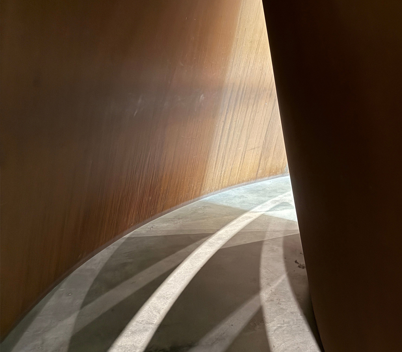 Curved architectural passage opening into natural light