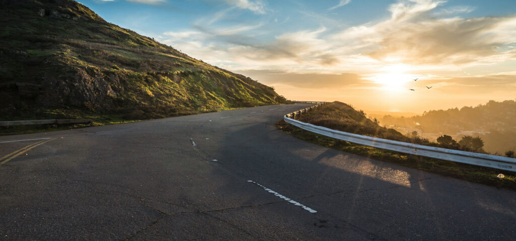 Open road curving toward the horizon at sunset